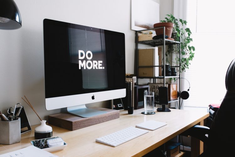 Escritorio con iMac, en la pantalla pone: Do More